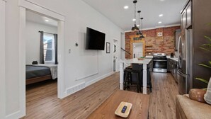 Un appartamento moderno con cucina, zona pranzo e camera da letto.