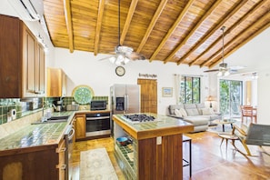 Une cuisine avec un plafond en bois, un réfrigérateur, un four à micro-ondes et une cuisinière.