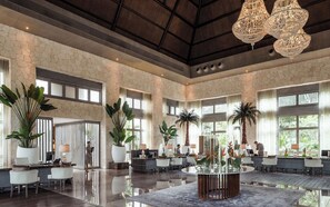 A spacious lobby with a high ceiling, large windows, and a central reception desk. - Beachfront Grand Luxxe Spa Suite 3 BEDRM (Nuevo Nayarit)