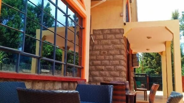 Un espace extérieur aménagé avec des meubles en osier et un mur en pierre.