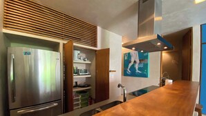 Una cucina moderna con frigorifero in acciaio inossidabile, forno integrato e piano di lavoro in legno.
