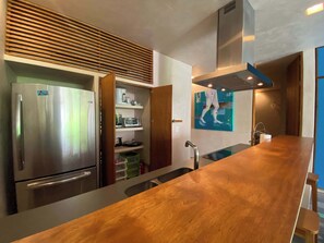 A modern kitchen with a stainless steel refrigerator, built-in oven, and a wooden countertop. - Sabor a Miel – Steps from the Beach and 5th Avenue (Playa del Carmen)