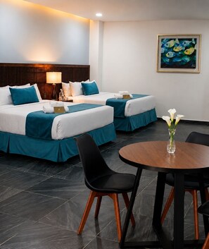 A hotel room with two beds, a dining table, and a vase of flowers. - Vita Grand Hotel  (Nuevo Nayarit)
