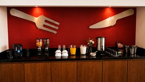 A bar area with a red wall, a wooden counter, and various bar tools and equipment. - Vita Grand Hotel  (Nuevo Nayarit)