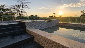 A swimming pool with tiled steps and a glass railing, surrounded by greenery and a clear sky. - Vita Grand Hotel  (Nuevo Nayarit)