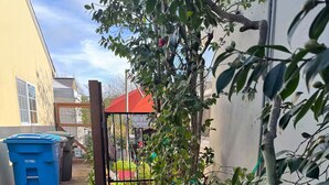 Un sendero estrecho conduce a una entrada con puerta de rejas y un cartel que da la bienvenida a los visitantes.