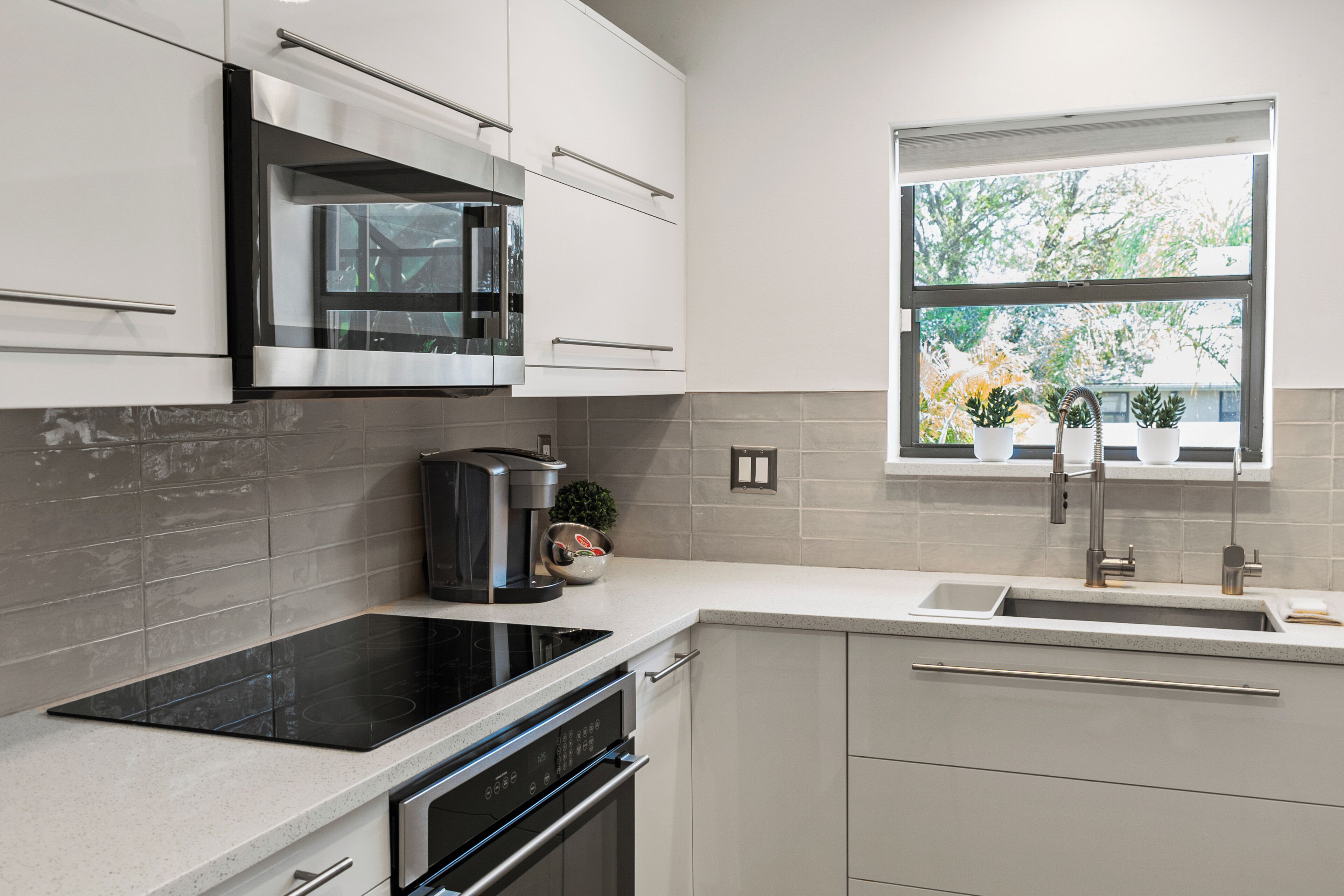 A modern kitchen with a built-in oven, a stovetop, and a sink.