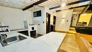 Une cuisine moderne dotée d’un grand îlot central, d’un évier encastré et d’un plancher en bois.