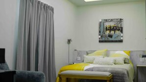 Ein modernes Schlafzimmer mit Bett, Deckenventilator, Klimaanlage und einem Wandbild.