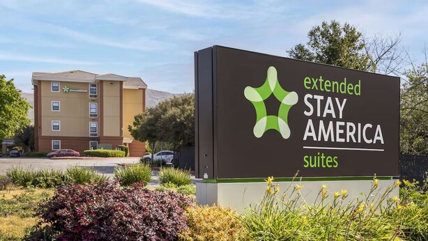 Une enseigne indiquant les suites de la chaîne Extended Stay America, avec un bâtiment en arrière-plan.