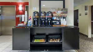 Un espace d’accueil d’hôtel comprenant un coin café, des distributeurs de collations et un comptoir où sont exposés divers articles.