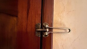 Una puerta de madera con un cerrojo metálico.