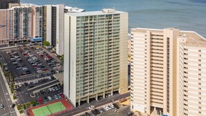 Um hotel moderno com um amplo estacionamento e quadra de tênis.