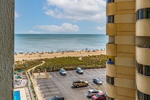 A view of a beach with a parking lot and a building with balconies. - Ocean View 2 Bedroom-2 Bathroom (Ocean City)
