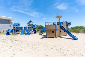 En strandlegeplads med rutsjebaner og klatrestrukturer.