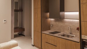 A modern kitchen with wooden cabinets, a stainless steel sink, and a built-in oven. - Zins Luxury Apartment 05 (Durrës)