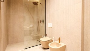 A modern bathroom with a glass-enclosed shower, a toilet, and a sink. - Zins Luxury Room Vollga (Durrës)