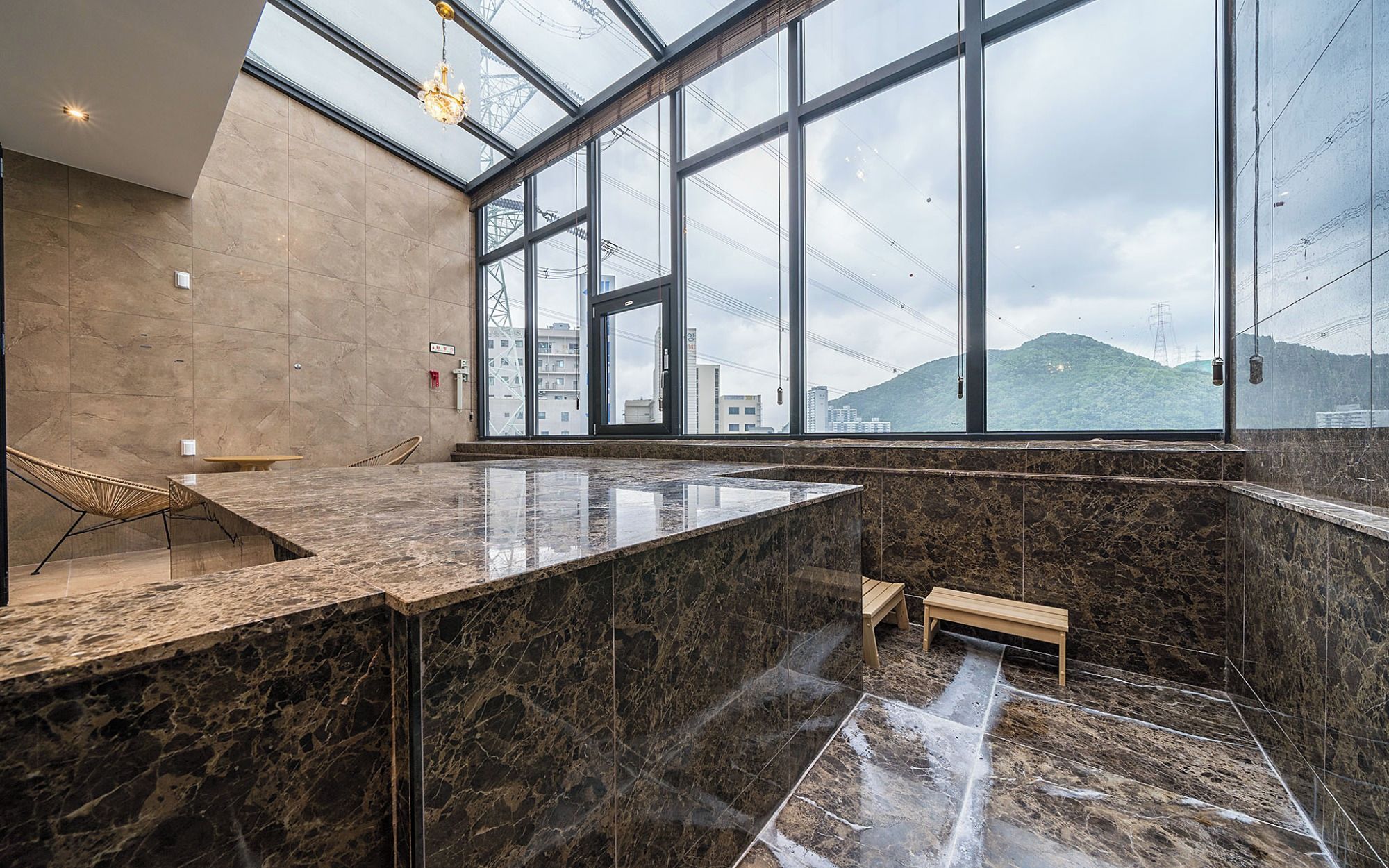 Ein modernes Interieur mit einem großen Glasfenster, einer Marmorarbeitsplatte und einer Bank.