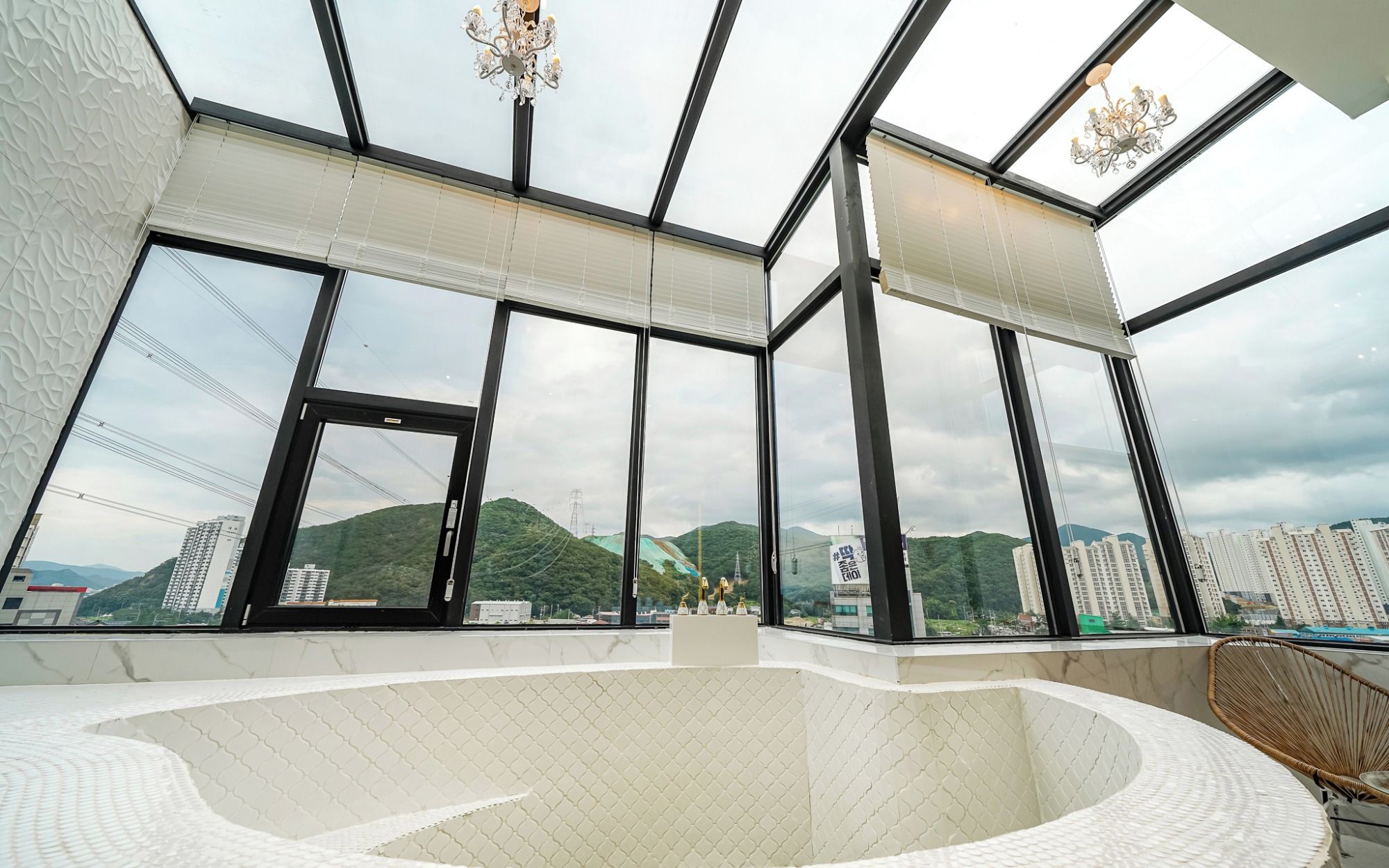 A modern interior with large windows, a central seating area, and a view of a cityscape.