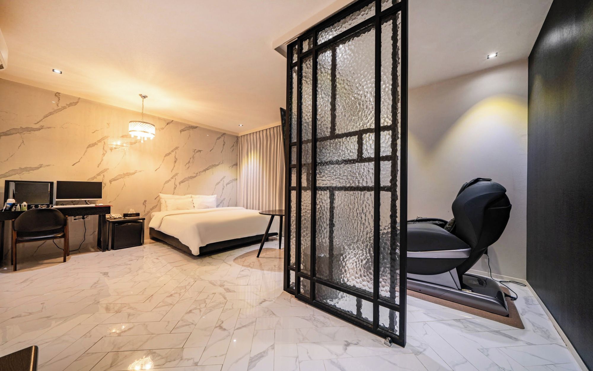 Ein modernes Hotelzimmer mit Bett, Schreibtisch, Stuhl und einem separaten Badebereich.