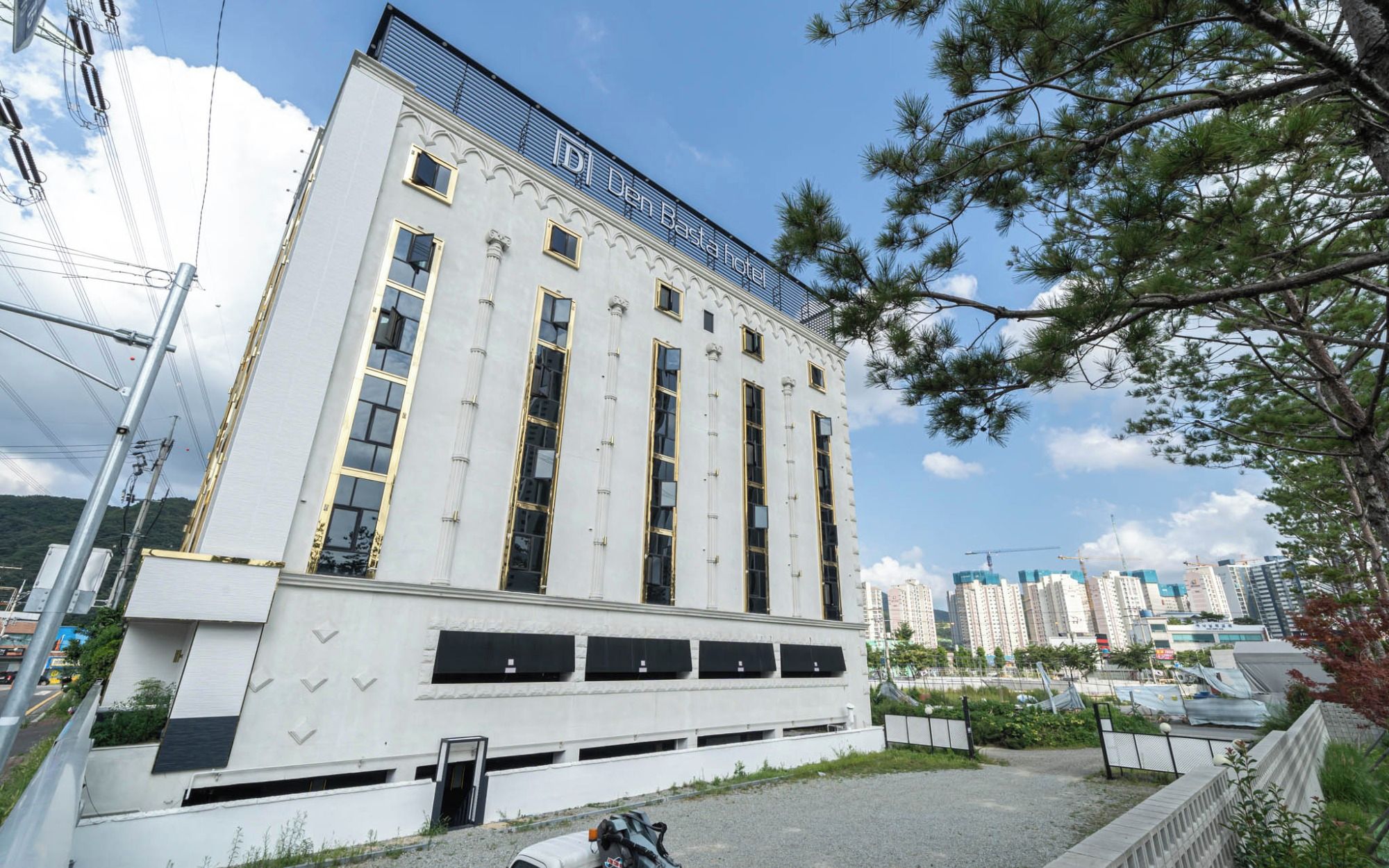 A modern building with a prominent sign reading 'Den Basta hotel'.