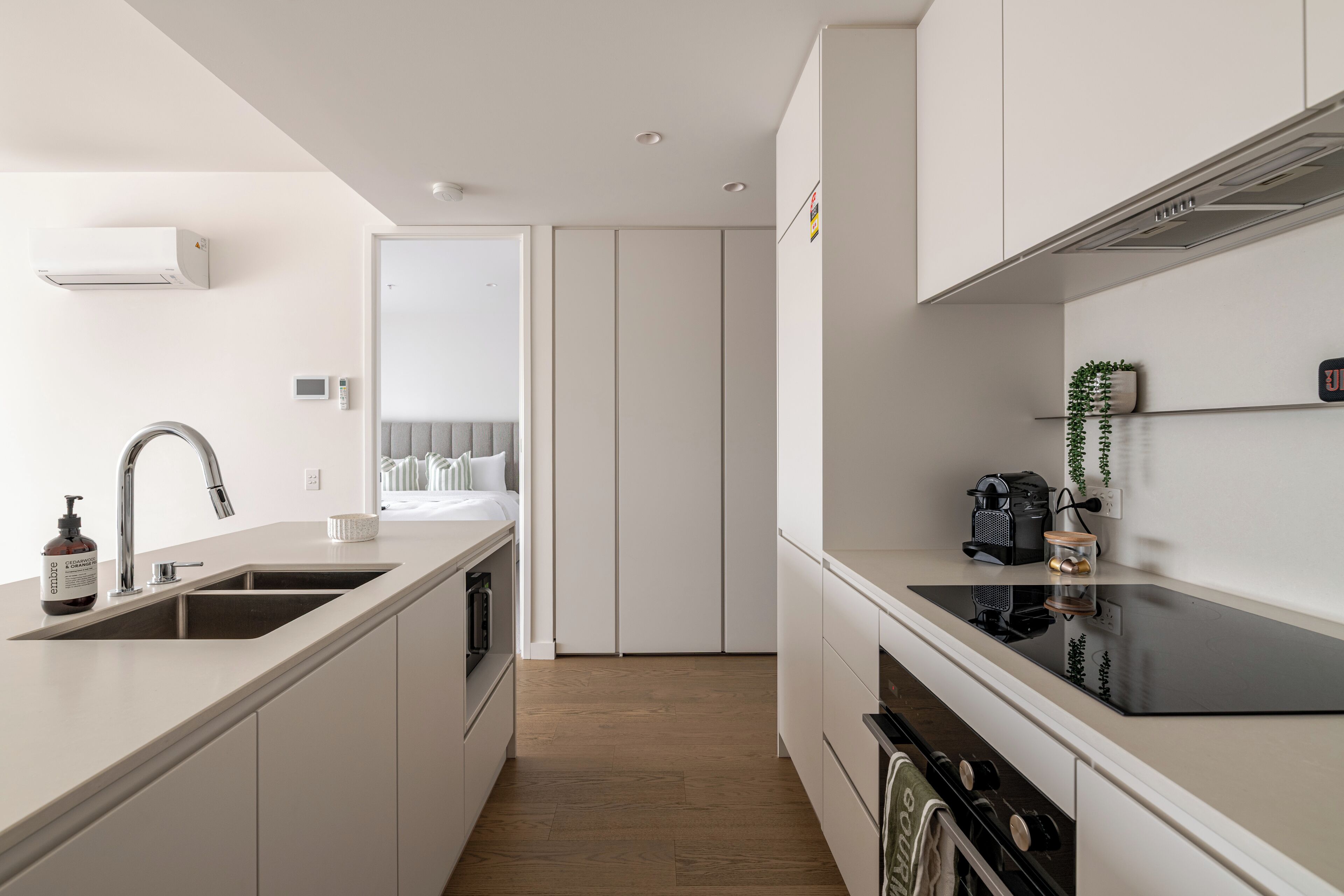A modern kitchen with a built-in oven, a sink, and a stove.