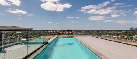 Una piscina infinita en la azotea con vistas despejadas al horizonte de la ciudad.