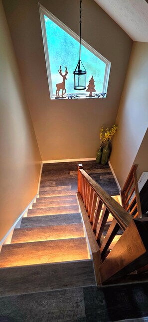 Eine Treppe mit Holzboden und Holzhandlauf, die zu einem Raum mit Oberlicht führt.