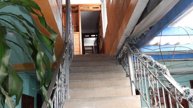 A staircase with metal railings, leading to an open doorway at the top.