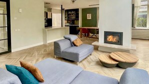 Una sala de estar moderna con un conjunto de sofás, una chimenea y un comedor.