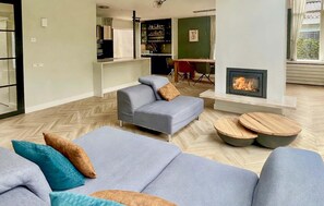 A modern living room with a sofa set, a fireplace, and a dining area. - Lovely home in Apeldoorn with WiFi (Apeldoorn)