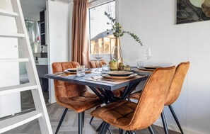 A dining area with a rectangular table set for four, surrounded by four brown upholstered chairs with black legs. - 2 bedroom stunning home in Wenum-Wiesel (Wenum-Wiesel)