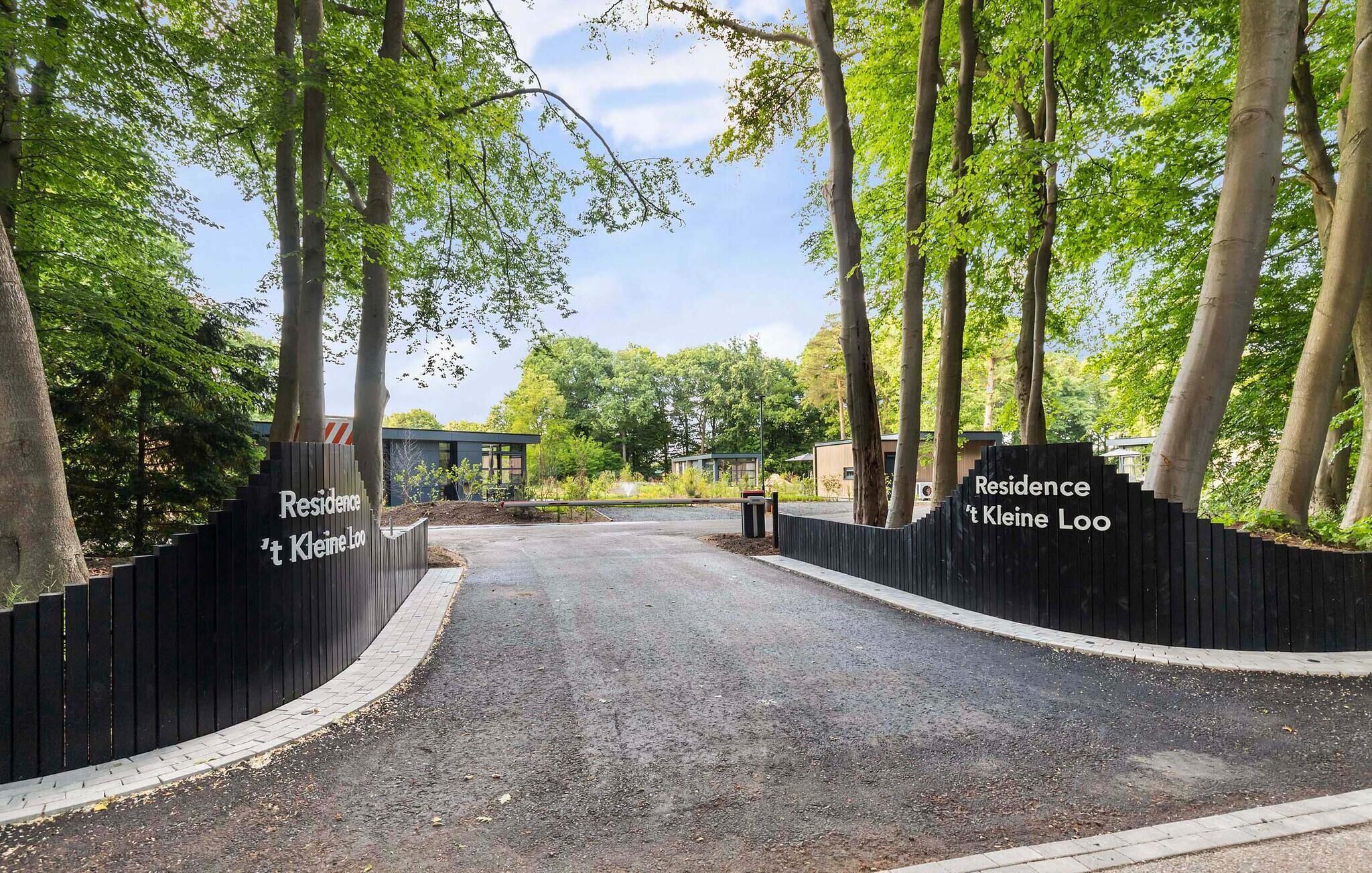 A gated entrance to a residential area with two signs reading "Residence 't Kleine Loo".