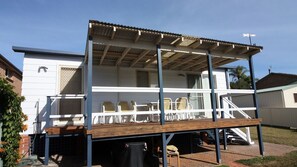 A two-story house with a covered patio area. - In Holiday Mode is a basic house in Manyana (Manyana)