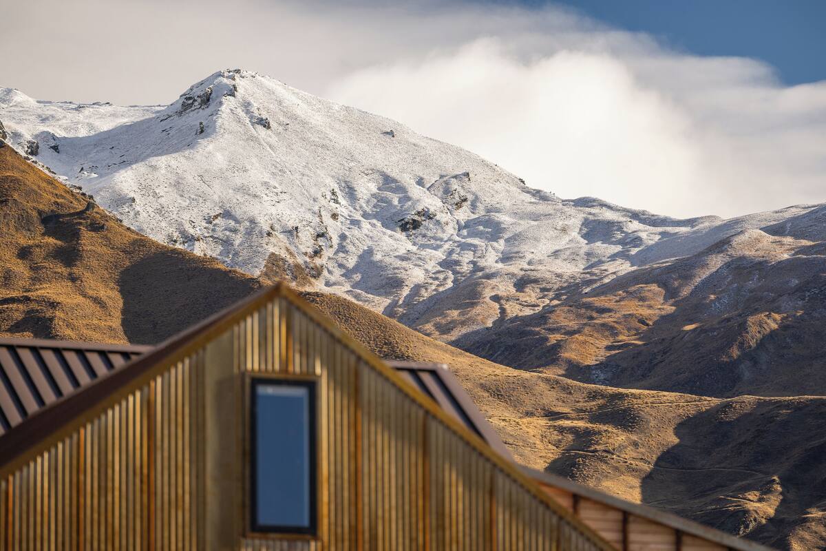 A wooden cabin with a view of a snow-covered mountain.
