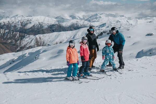 A group of people on a snowy mountain with a clear view of distant mountains.