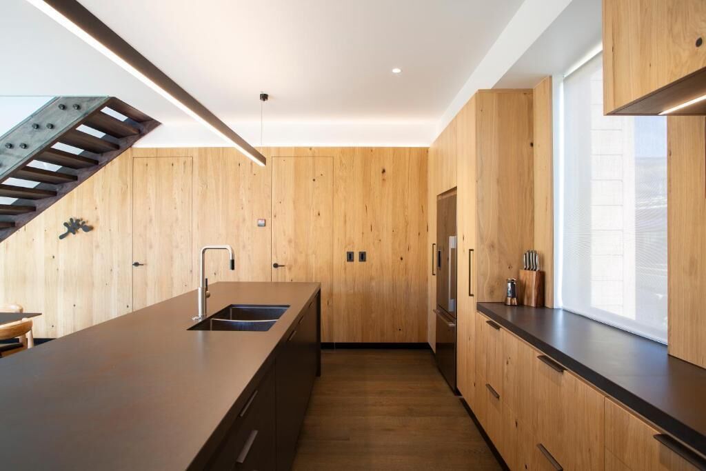 Una cocina moderna con armarios de madera, una encimera larga y una estufa integrada.