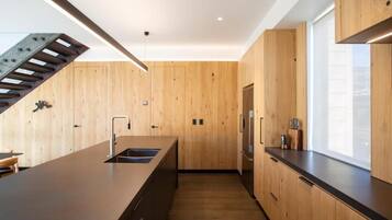 Una cocina moderna con armarios de madera, una encimera larga y una estufa integrada.