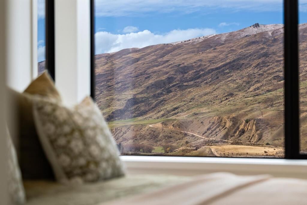 A room with a large window overlooking a mountainous landscape.