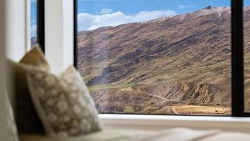 A room with a large window overlooking a mountainous landscape.