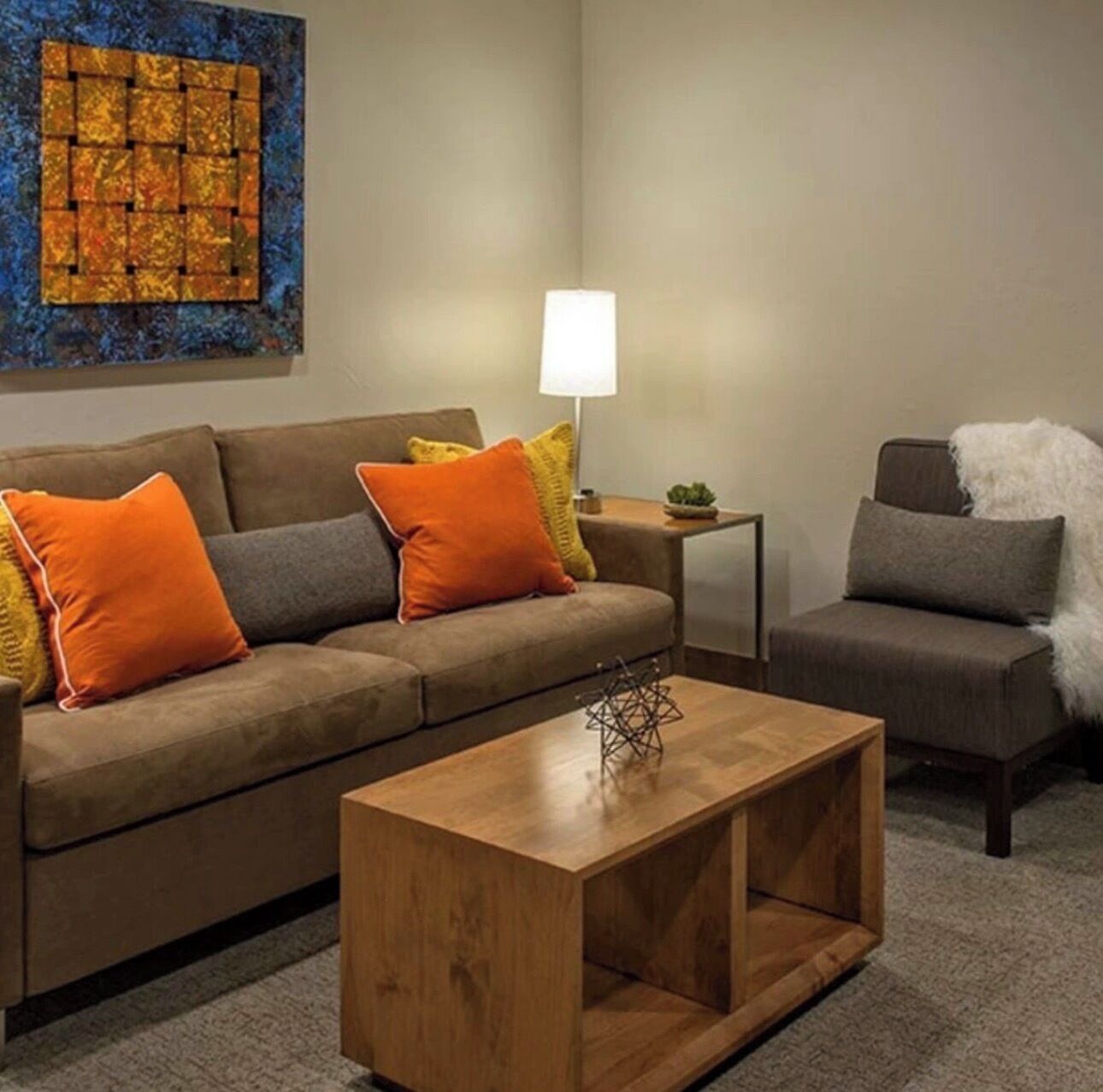 A living room with a sofa, a coffee table, and a lamp.