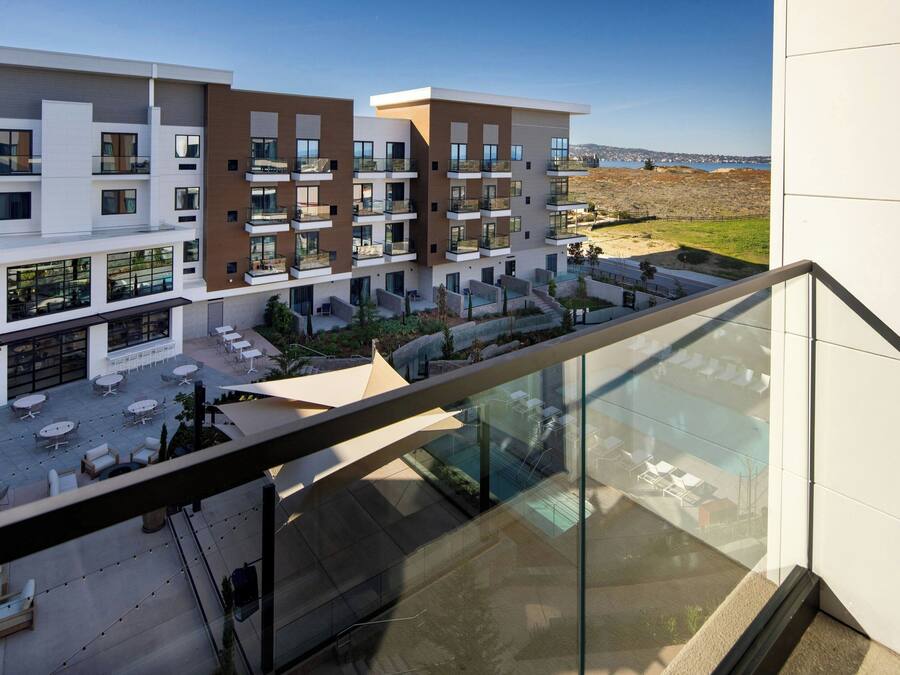 A modern building with multiple balconies and outdoor seating areas.