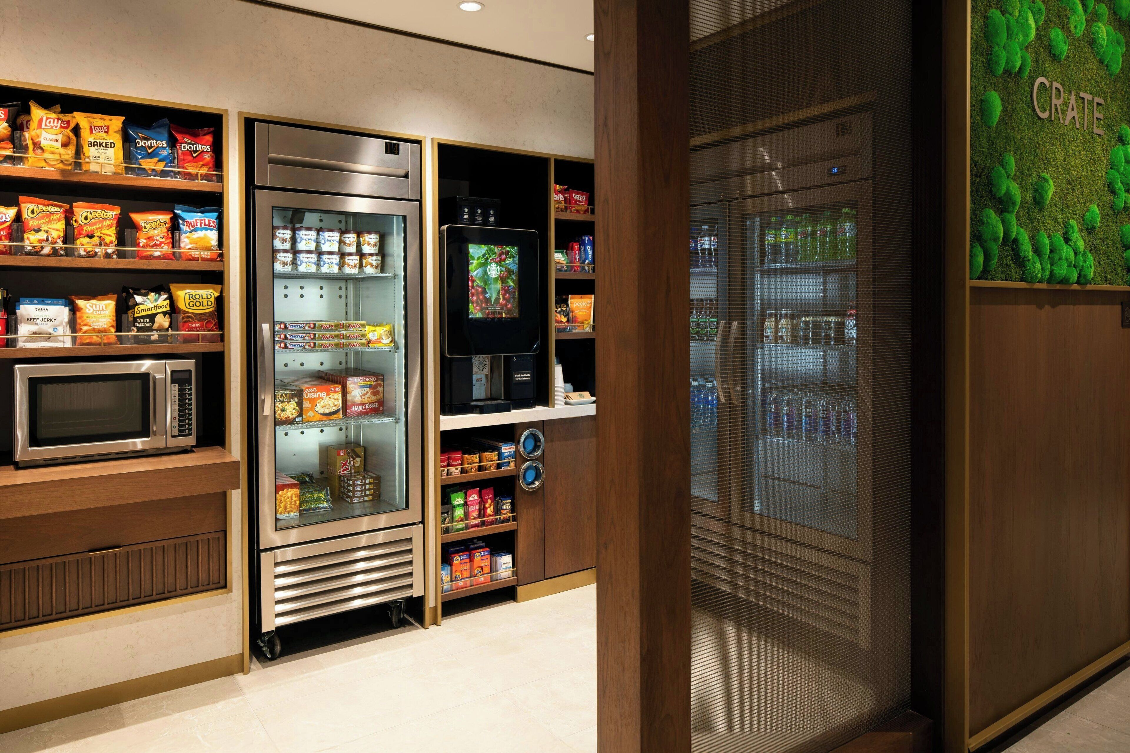 A snack vending machine with various snack options, a microwave, and a refrigerator.