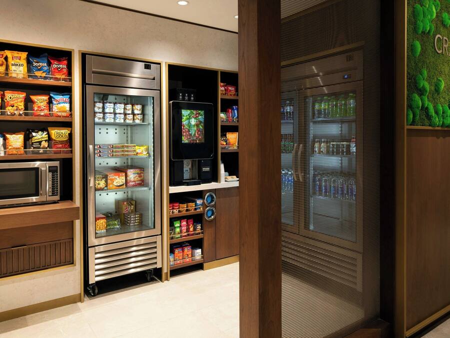A snack vending machine with various snack options, a microwave, and a refrigerator.