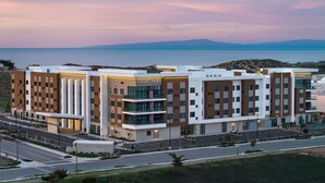 A modern hotel with multiple floors, a courtyard, and a view of the sea. - Courtyard By Marriott Sand City Monterey (Seaside)