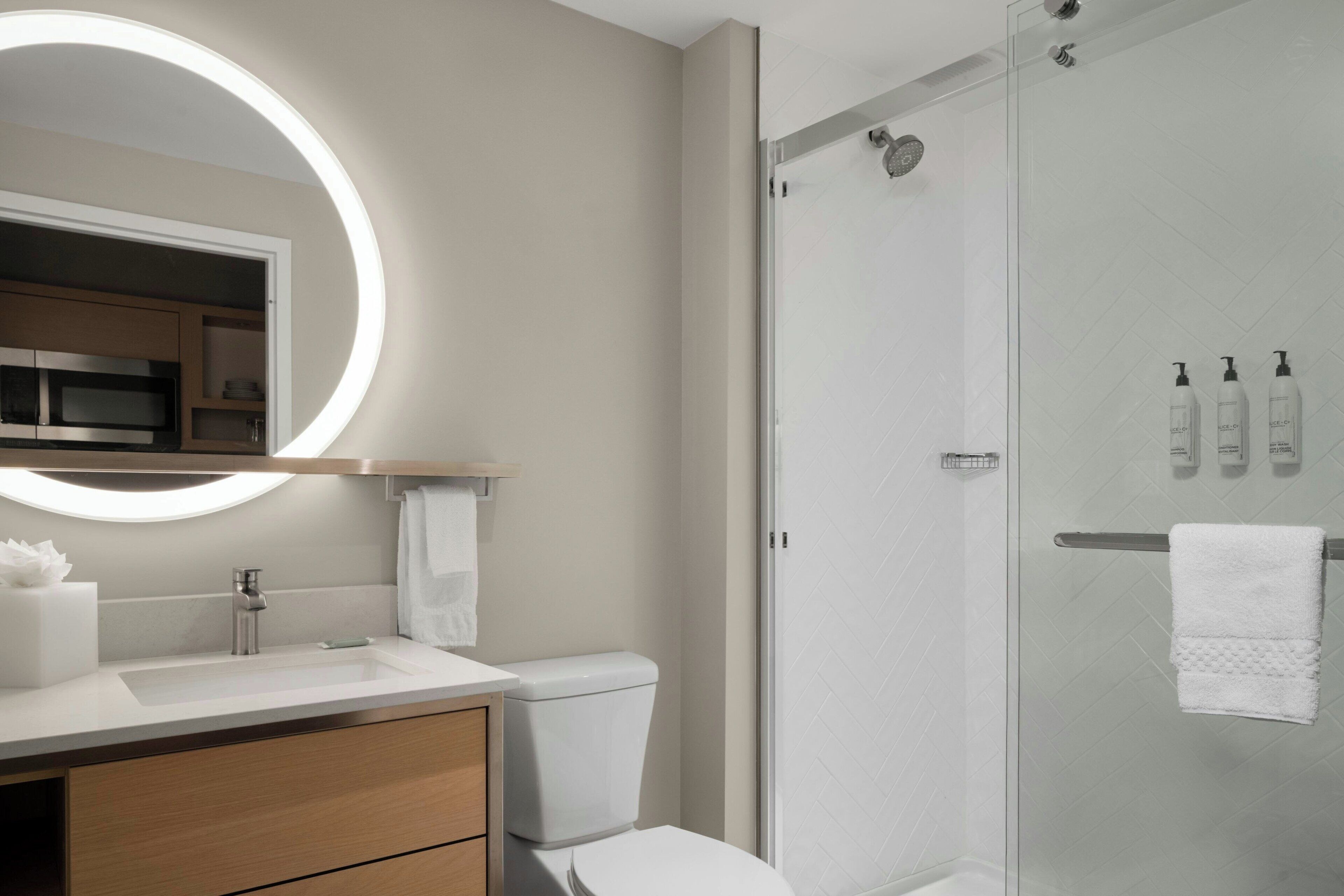 Un baño moderno con inodoro, lavamanos y ducha.