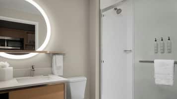 Un baño moderno con inodoro, lavamanos y ducha.