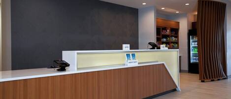 Una reception dal design moderno, con uno schermo digitale e una segnaletica che indica una struttura Marriott Bonvoy.