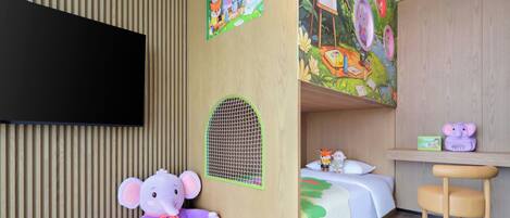 A child's room with a bed, desk, and a large TV.