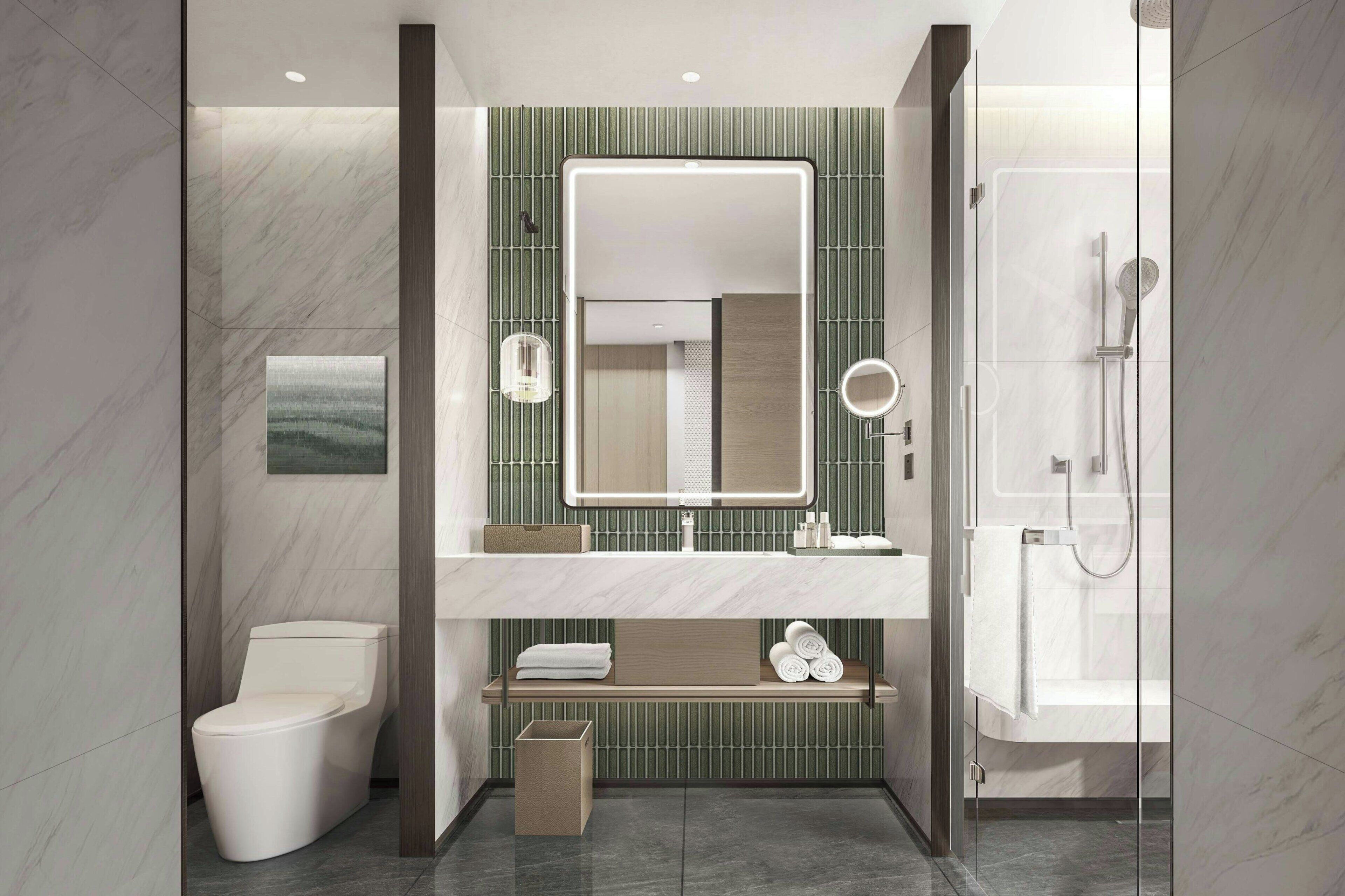 A modern bathroom with a toilet, sink, mirror, and shower.